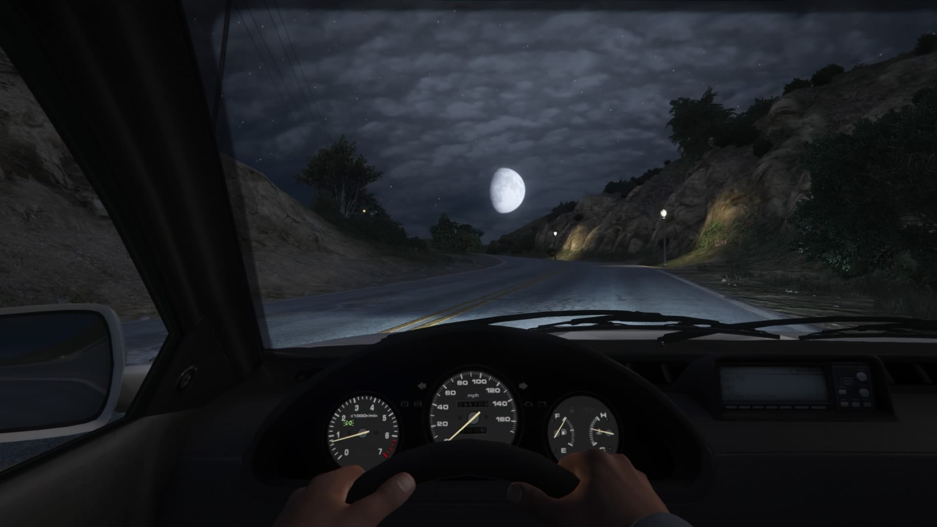 A player driving in GTA V at night, on an empty room towards a full moon. 