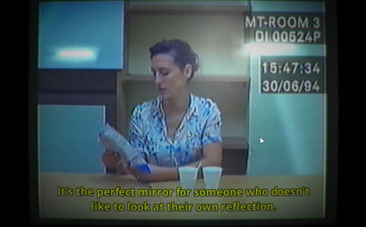 Archive footage on an old PC monitor, showing a lady reading a script in an office room.