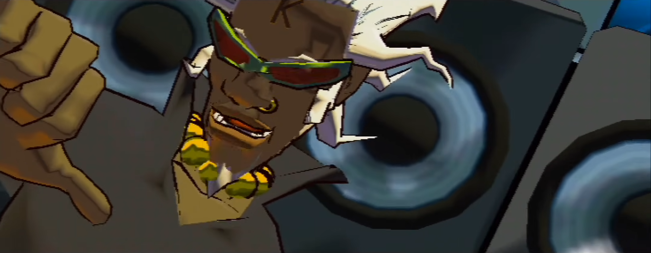 DJ Professor K makes a thumbs-down sign. He is surrounded by speakers.